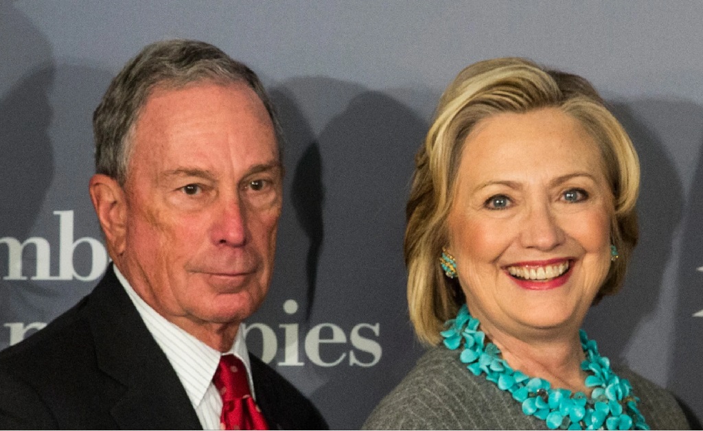 Candidato democrata à presidência dos EUA, Michael Bloomberg é visto conversando ao pé do ouvido com Hillary Clinton