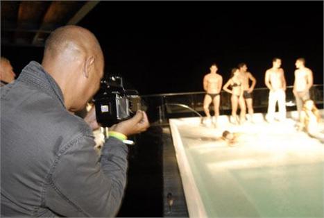 Diretor de estilo da revista norte-americana Vanity Fair, Michael Roberts, com uma câmera profissional em punho, registra neste exato momento os melhores momentos do desfile-performance da Calvin Klein na piscina do Fasano do Rio.